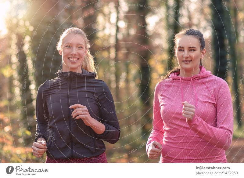 Two attractive fit young ladies out jogging Lifestyle Happy Face Sports Jogging To talk Woman Adults Friendship 2 Human being 18 - 30 years Youth (Young adults)