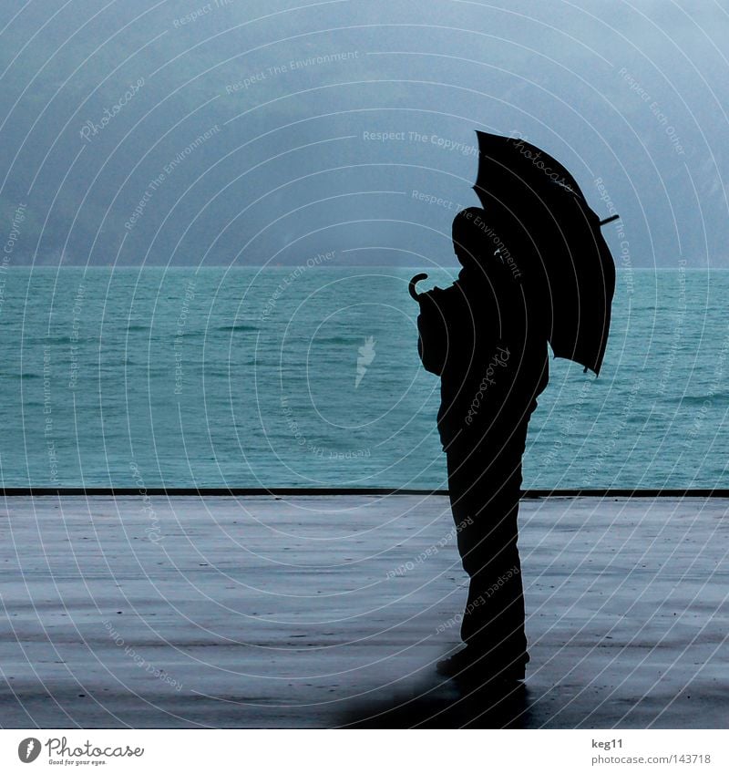 Dancing in the Rain Switzerland Lake Water Ocean Umbrella Drops of water Bad weather Roof Rain jacket Man Loneliness Blue Gray Sky 3 Human being Silhouette
