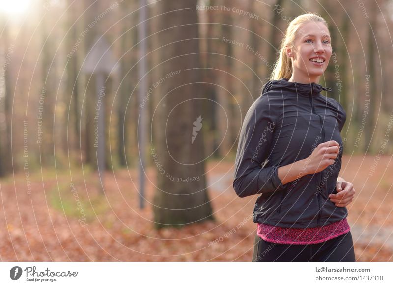 Pretty fit young woman jogging in woodland Diet Lifestyle Body Face Sports Jogging Woman Adults Nature Autumn Forest Blonde Fitness Smiling Fresh athletic