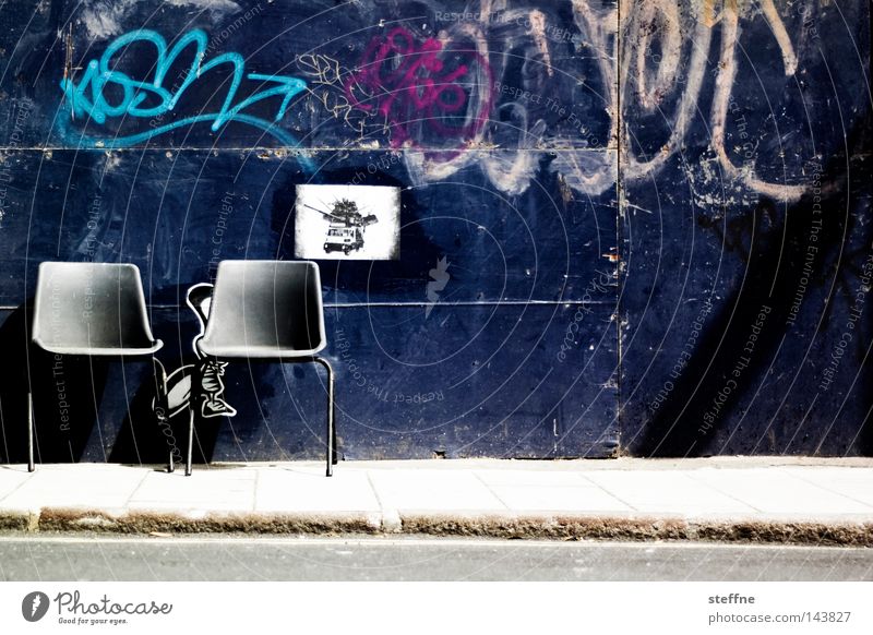 Take a seat Chair Stool Seating Wall (building) Street Gate Graffiti Traffic infrastructure Furniture