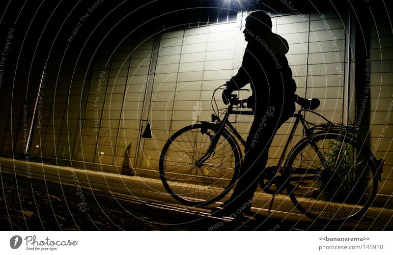 waiting on the bike Bicycle Night Dark Light Driving Man Wall (building) Lamp Cold Jacket Leisure and hobbies Shadow Wait Sit Guy Street Industrial Photography