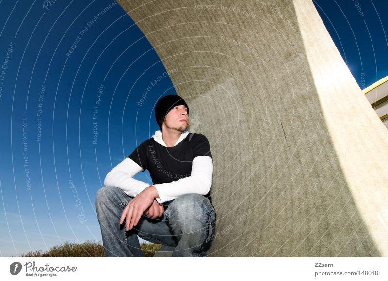 curve Stand Human being Man Cap Style Round Concrete Construction site Sky Easygoing Wide angle Motionless Material Think Architecture Center point Jeans Blue