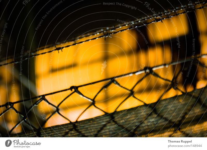 fence Warehouse Hall Blur Large Lighting Fence Tall Wire Thorny Wire netting fence Pattern Barbed wire Building Orange Dark Narrow Loneliness Border Limitation