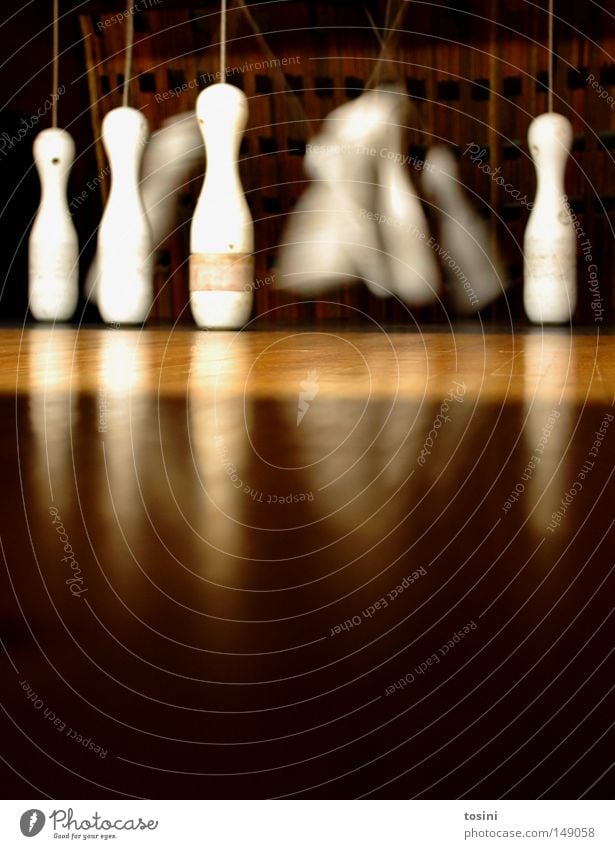 four left Nine-pin bowling Location Floor covering Ground Worm's-eye view Conical Skittle Sphere Tumble down Wood Brown Bowling Sports Sporting event Swing