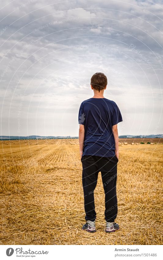 Youth stands on harvested field and looks into the distance Lifestyle Luxury Style Contentment Vacation & Travel Summer Human being Masculine Young man