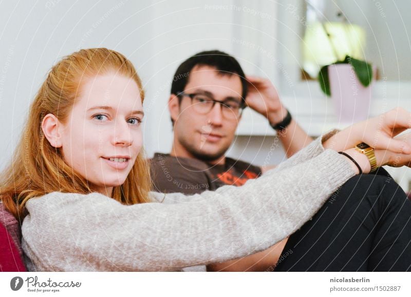 Young woman and young man sitting on a sofa in the living room and talking Well-being Contentment Leisure and hobbies Living or residing Flat (apartment) Room
