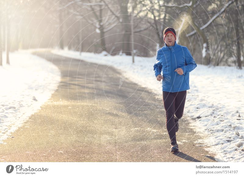 Man jogging in winter clothing Lifestyle Face Winter Snow Sports Jogging Adults 30 - 45 years Newspaper Magazine Park Street Breathe Fitness Determination