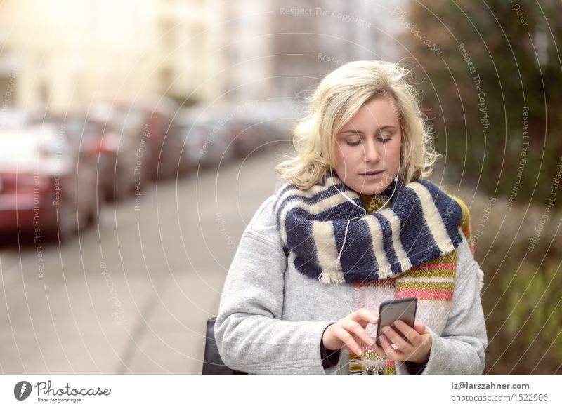Attractive blond woman checking her mobile phone Winter Business To talk Telephone Technology Woman Adults 1 Human being 30 - 45 years Street Fashion Blonde