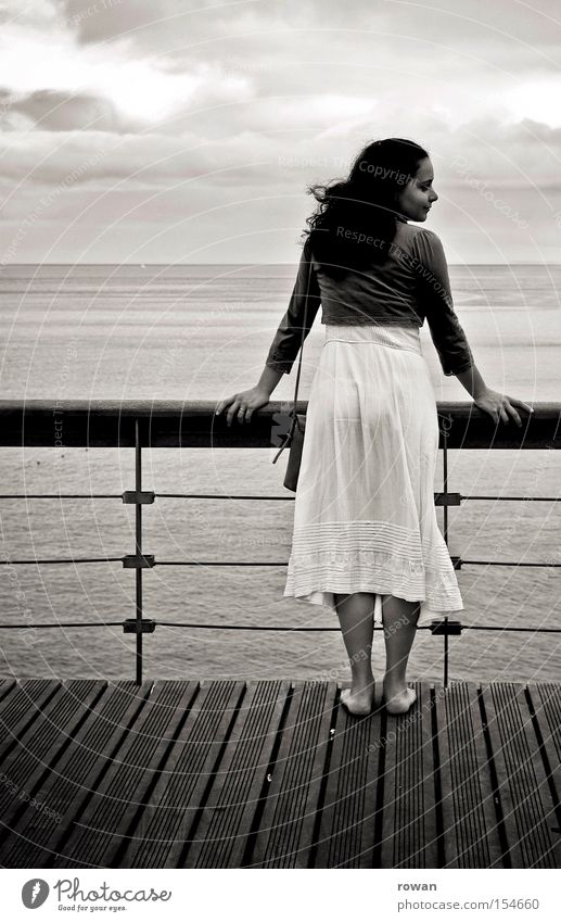 girl by the sea Woman Promenade Beach Lake Ocean Looking Vantage point Calm Cruise Watercraft Deck Barefoot Coast Black & white photo look of the shoulder