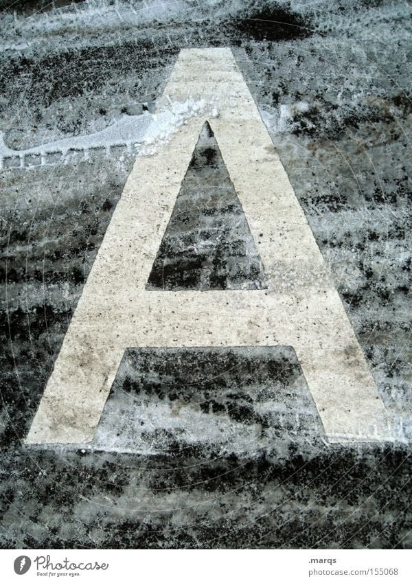 a Colour photo Subdued colour Exterior shot Detail Winter Snow Street Concrete Characters Cold Tracks Typography Asphalt Frozen Latin alphabet