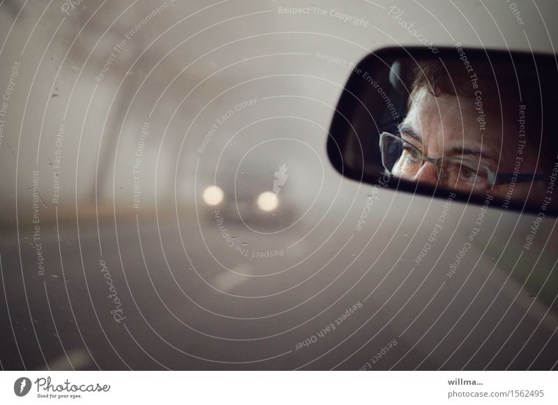 Driving in fog, eyes with glasses in rear view mirror Rear view mirror Fog Motoring Face Eyeglasses Concentrate Street fog lamps Floodlight Caution Watchfulness