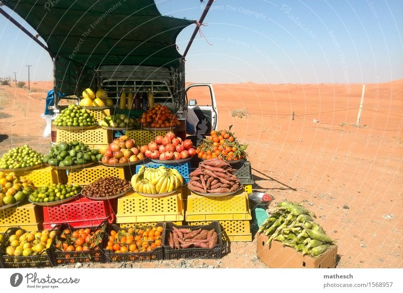 Fruit stand in the desert on the back of a pickup truck car Orange Mango Banana Sand Cloudless sky Desert Fresh Healthy Hot Delicious Sell Colour photo