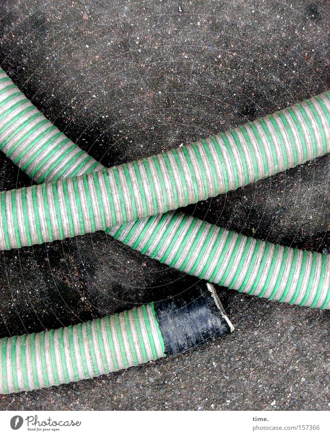 hollow back Work and employment Craft (trade) Concrete Green Safety Hose Striped Crossed Parallel Transmission lines Connection Colour photo Subdued colour