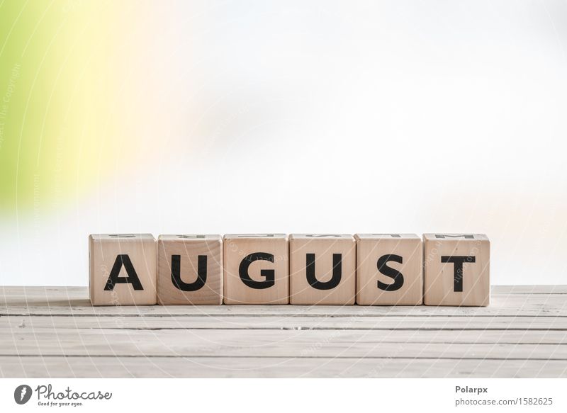 August sign on wooden cubes Design Playing Reading Vacation & Travel Summer Desk School Toys Wood Simple Green Colour Creativity Symbols and metaphors Text Word