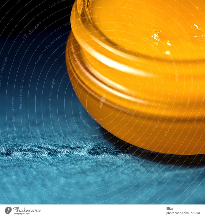 Close-up of a cream jar with an orange cream inside Gold Tin Plastic container turquoise Glittering Screw thread already Esthetic Macro (Extreme close-up)