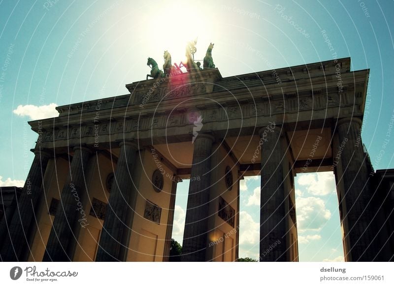 Brandenburg Gate against the light with blue sky Berlin Capital city Sun Summer Blooming Light Rider Carriage Horse Statue Monument Monumental Landmark Warmth