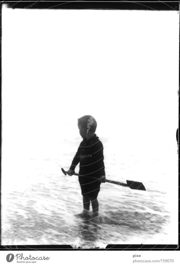 framework plot Child Black & white photo Historic Ocean Beach Playing Shovel Memory Souvenir Human being Vacation & Travel Offspring Boy (child) glass negative