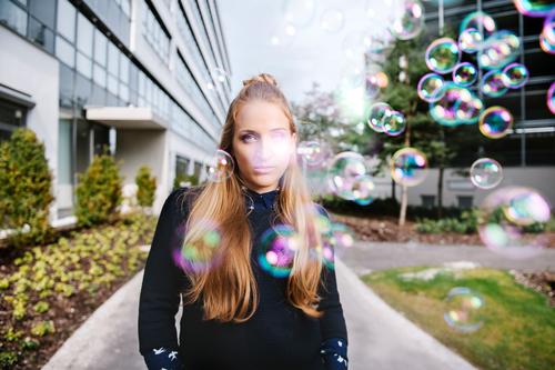 Young woman with soap bubbles in industrial environment Feminine Youth (Young adults) 1 Human being 18 - 30 years Adults Park Building Facade Blonde Long-haired