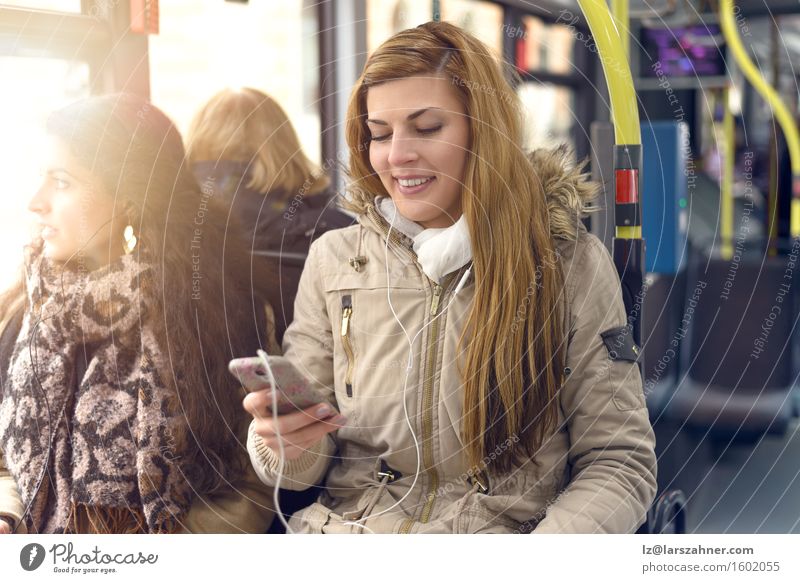 Happy woman reading a message on her mobile Reading Telephone PDA Technology Woman Adults 2 Human being 18 - 30 years Youth (Young adults) Public transit