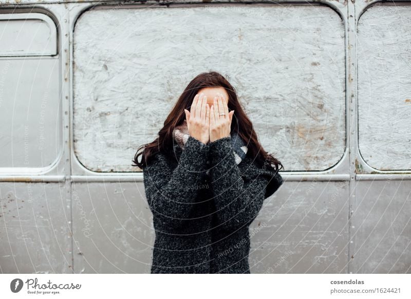Young woman hides her face behind her hands University & College student Feminine Youth (Young adults) Woman Adults 1 Human being Jacket Coat Brunette