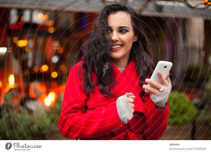 Woman in red coat with mobile phone in hands, smartphone, urban scene woman smile smiling lifestyle girl person cold winter female technology telephone cell