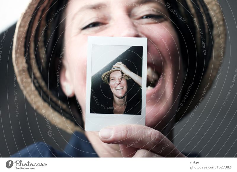 Laughing woman shows polaroid of a smiling woman Lifestyle Style Joy Leisure and hobbies Woman Adults Face 1 Human being 2 30 - 45 years Hat Straw hat