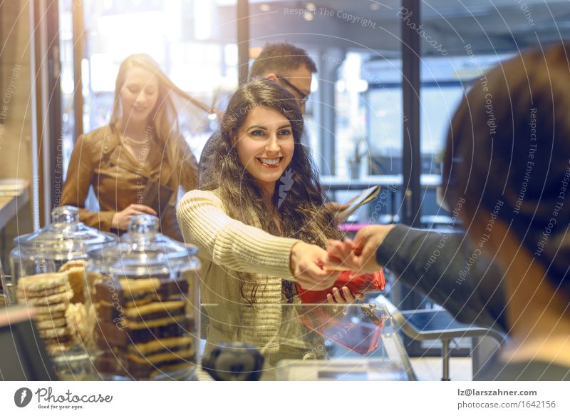 Attractive young woman paying in a shop Shopping Happy Woman Adults Paying attractive Bank note bar briunette Cafeteria Cashier Copy Space counter Customer