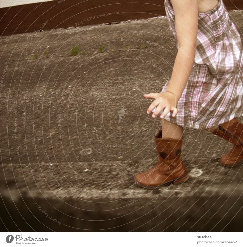 on the wall, on the ... Child Girl Wall (barrier) Summer Asphalt Dress Boots Pattern Contentment Highway ramp (entrance) Swing Movement Walking Human being