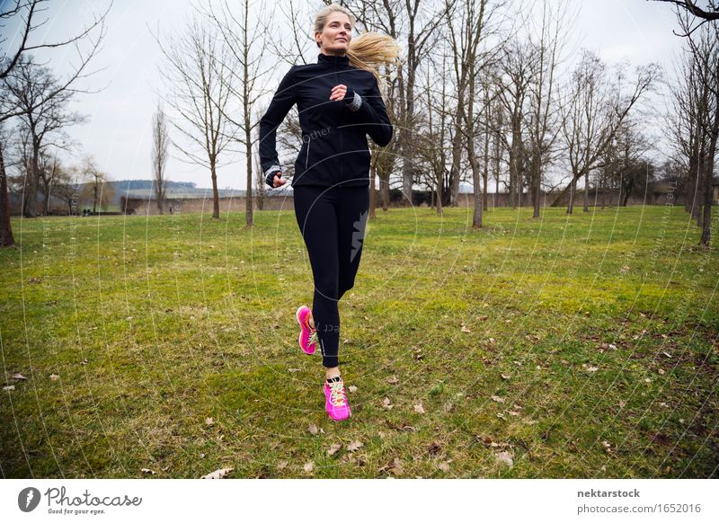 blonde woman running in park Lifestyle Body Wellness Winter Sports Jogging Human being Woman Adults Grass Park Movement Fitness Athletic Speed Practice healthy