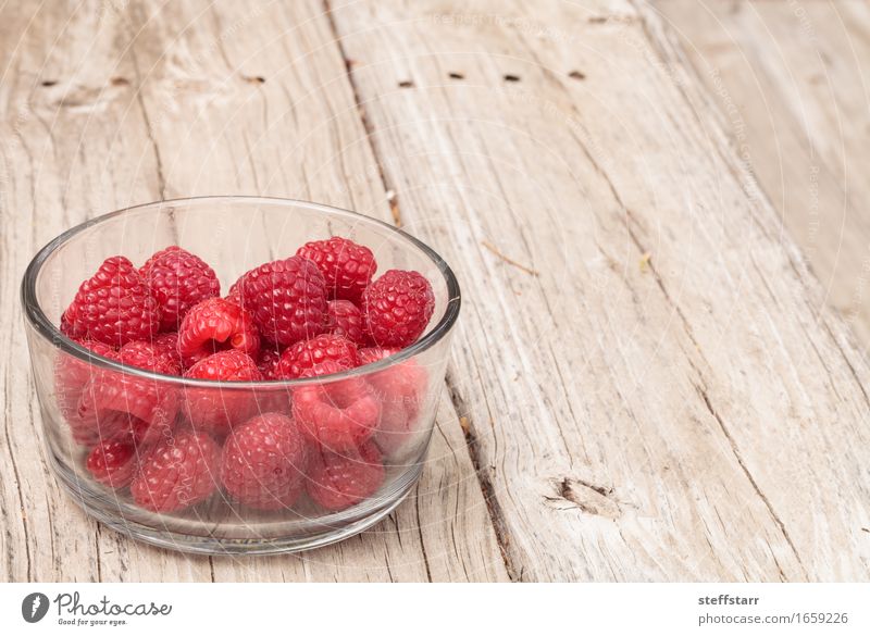 Clear glass bowl of ripe raspberries Food Fruit Nutrition Eating Breakfast Picnic Bowl Glass Healthy Plant Wood Diet Pink Red Colour photo Multicoloured