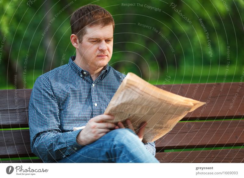 Man reads newspaper on bench in the park Lifestyle Happy Relaxation Reading Garden Business Human being Young man Youth (Young adults) Adults 1 18 - 30 years