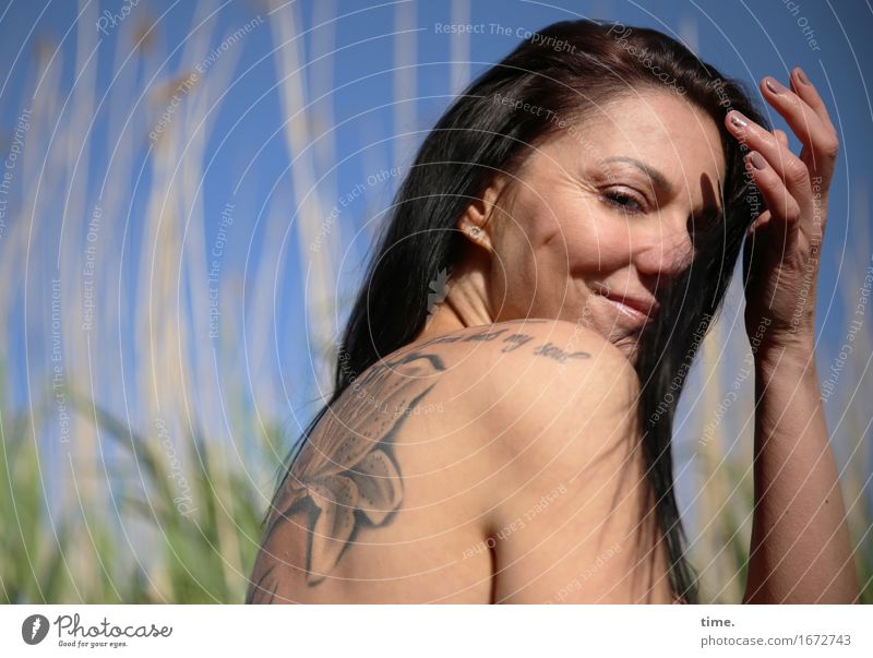 In the reeds Feminine 1 Human being Beautiful weather Common Reed River bank Beach Tattoo Black-haired Long-haired Observe Relaxation Smiling Looking Wait
