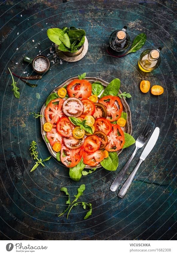 Tomato salad with coloured tomatoes, cutlery and dressing Food Vegetable Lettuce Salad Herbs and spices Cooking oil Nutrition Banquet Organic produce