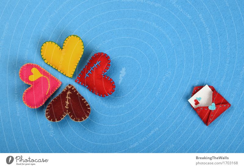 Four colorful handmade stitched toy hearts on blue felt Lifestyle Design Leisure and hobbies Handicraft Handcrafts Valentine's Day Art Work of art Toys Heart