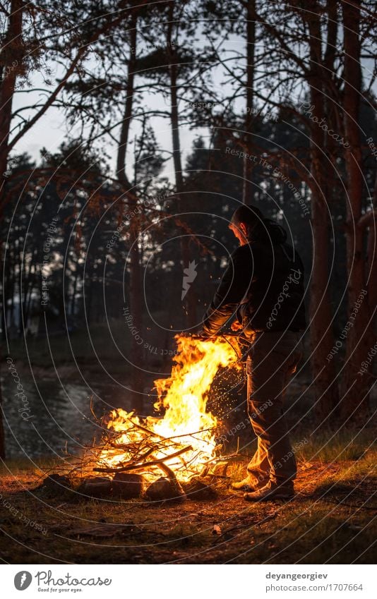 Man lights a fire in the fireplace Leisure and hobbies Vacation & Travel Tourism Adventure Camping Summer Mountain Hiking Human being Adults Nature Warmth Tree