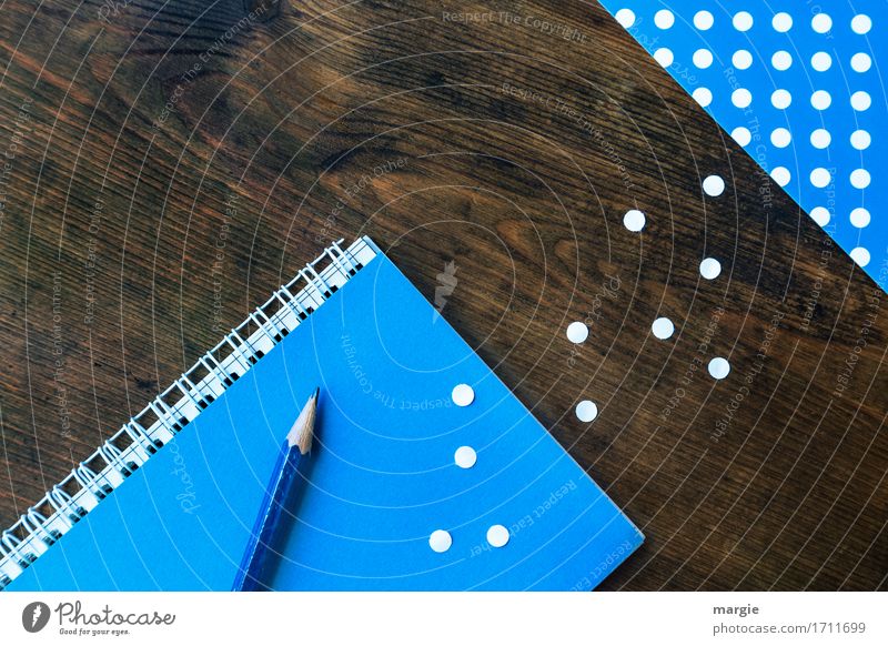 Collect points: pencil, notebook, pad, with blue paper and white dots on a wooden desk Profession Office work Workplace Trade Media industry