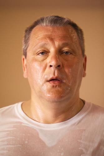 Tired looking hot perspiring middle-aged man after a workout, closeup head and shoulders portrait looking directly at the camera Face Health care Wellness