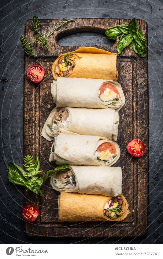 Various tasty tortilla wraps on rustic chopping board Food Vegetable Lettuce Salad Herbs and spices Nutrition Lunch Dinner Buffet Brunch Organic produce Diet