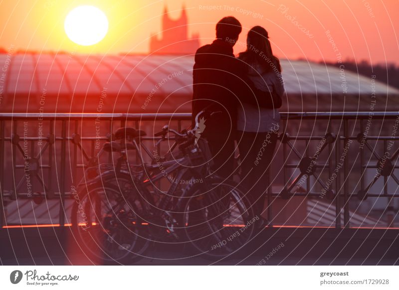 Young couple embracing and enjoying beautiful sundown in the city from the viewing point Happy Sun Stadium To talk Human being Young woman Youth (Young adults)