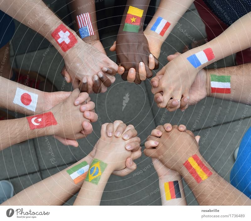 Nations hand in hand - people of different nationalities with painted flags holding hands as a sign of peace and solidarity Human being by hand Group Sign Flag