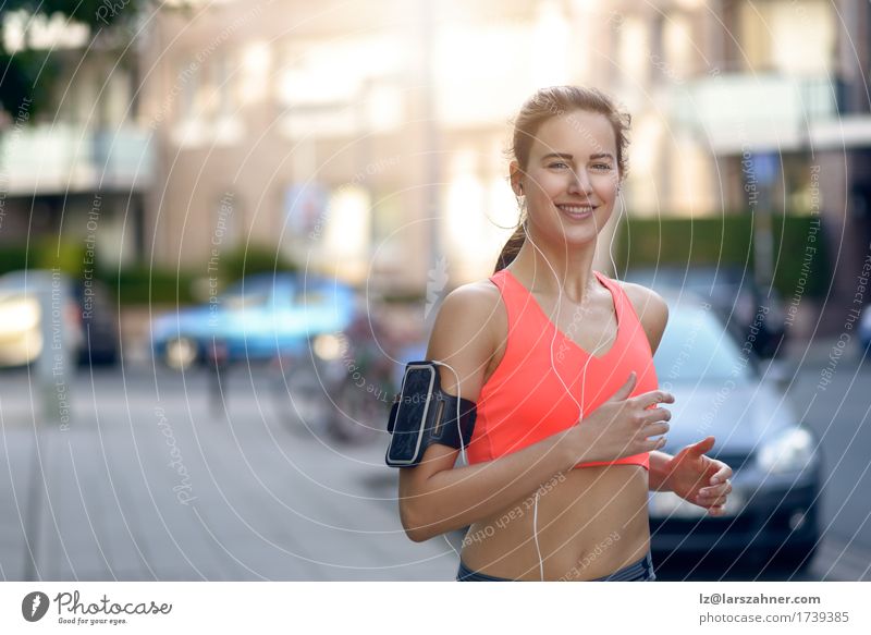 Fit young woman jogging along an urban street Young woman Youth (Young adults) Woman Adults 1 Human being 18 - 30 years Healthy concept Lifestyle Running