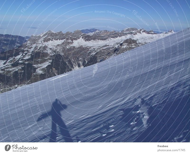 boarder Snowboard Alps Mountain Snowcapped peak Shadow Snow layer Carrying Upward Snowboarder Winter vacation Slope Panorama (View) Beautiful weather