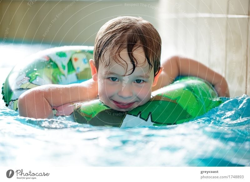 Young boy in inflatable tube swimming with a big smile on his face Joy Happy Relaxation Spa Swimming pool Child Boy (child) 3 - 8 years Infancy Water Ring