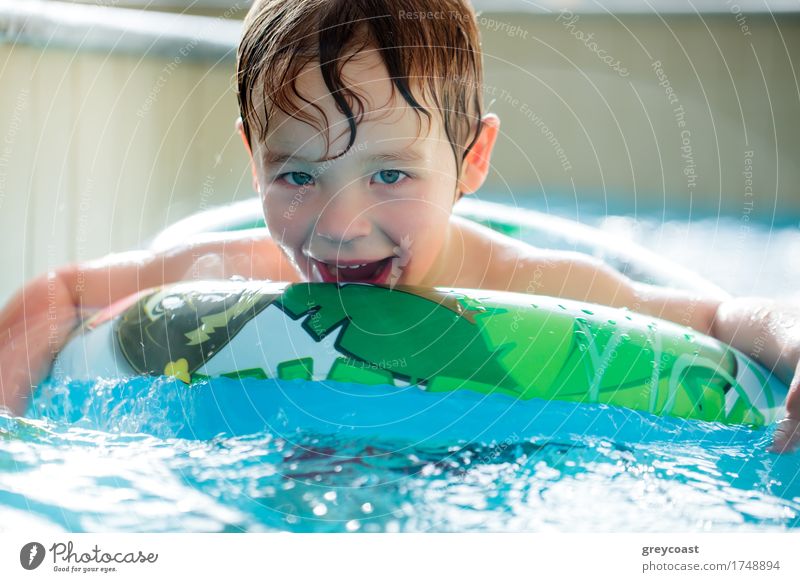 Cute boy in inflatable ring having fun in the swimming pool Joy Happy Relaxation Spa Swimming pool Child Boy (child) 1 Human being Water Ring To enjoy Smiling