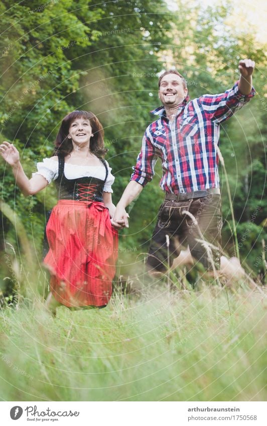 Young couple in traditional costume has fun Lifestyle Joy Tourism Trip Summer vacation Garden Oktoberfest Human being Masculine Feminine Young woman