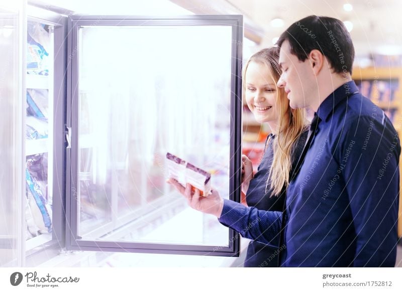 Couple in the frozen goods section of a grocery store picking out food from the freezer Shopping Happy Human being Woman Adults Man Family & Relations