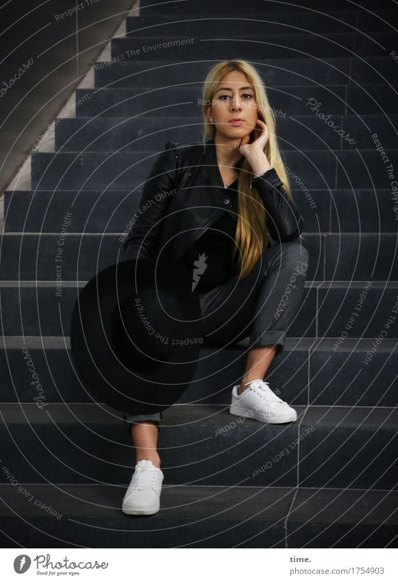 . Feminine 1 Human being Wall (barrier) Wall (building) Stairs Pants Jacket Sneakers Hat Blonde Long-haired Observe Think To hold on Looking Sit Wait Beautiful