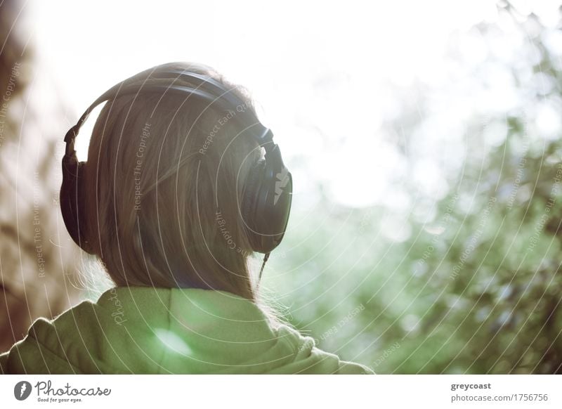 Vintage photo of a woman in headphones listening to music outdoor against bright sunlight. Instagram style color toned Style Relaxation Leisure and hobbies Sun