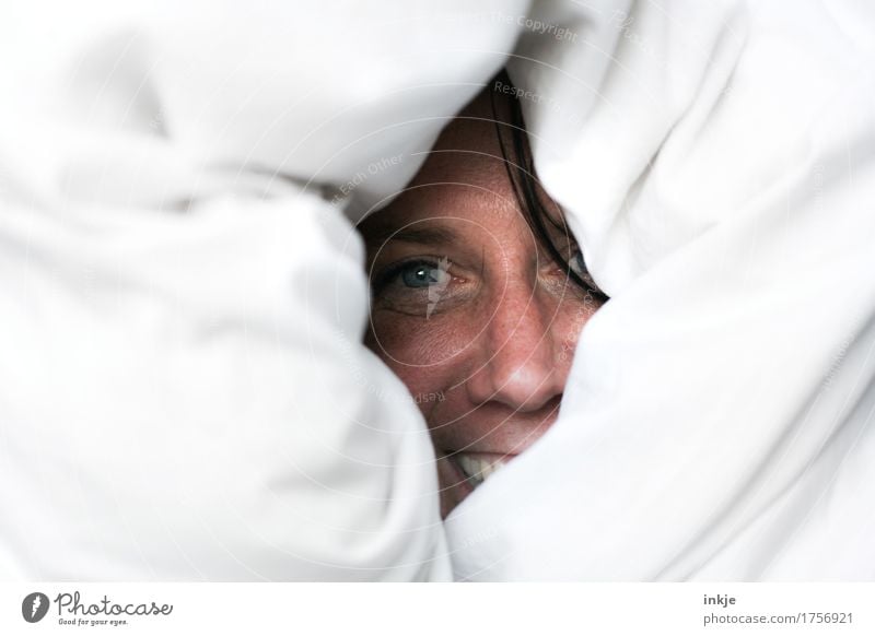 Female face looks laughing from the duvet Lifestyle Joy Leisure and hobbies Woman Adults Face 1 Human being 30 - 45 years Duvet Bedclothes smile Laughter