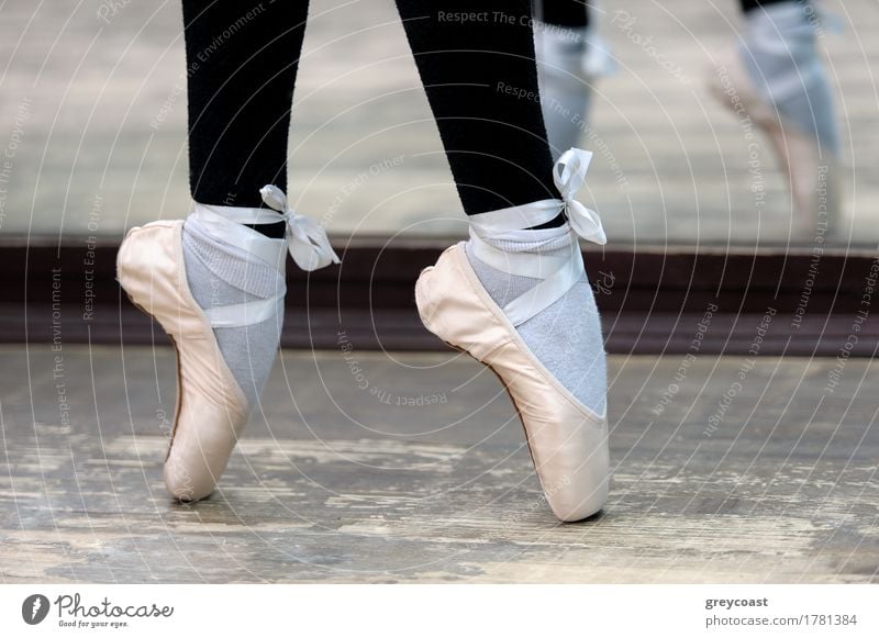 Close up view to ballerinas legs in white pointes on wooden floor in point position. Elegant Style Beautiful Dance School Profession Girl Feet 1 Human being